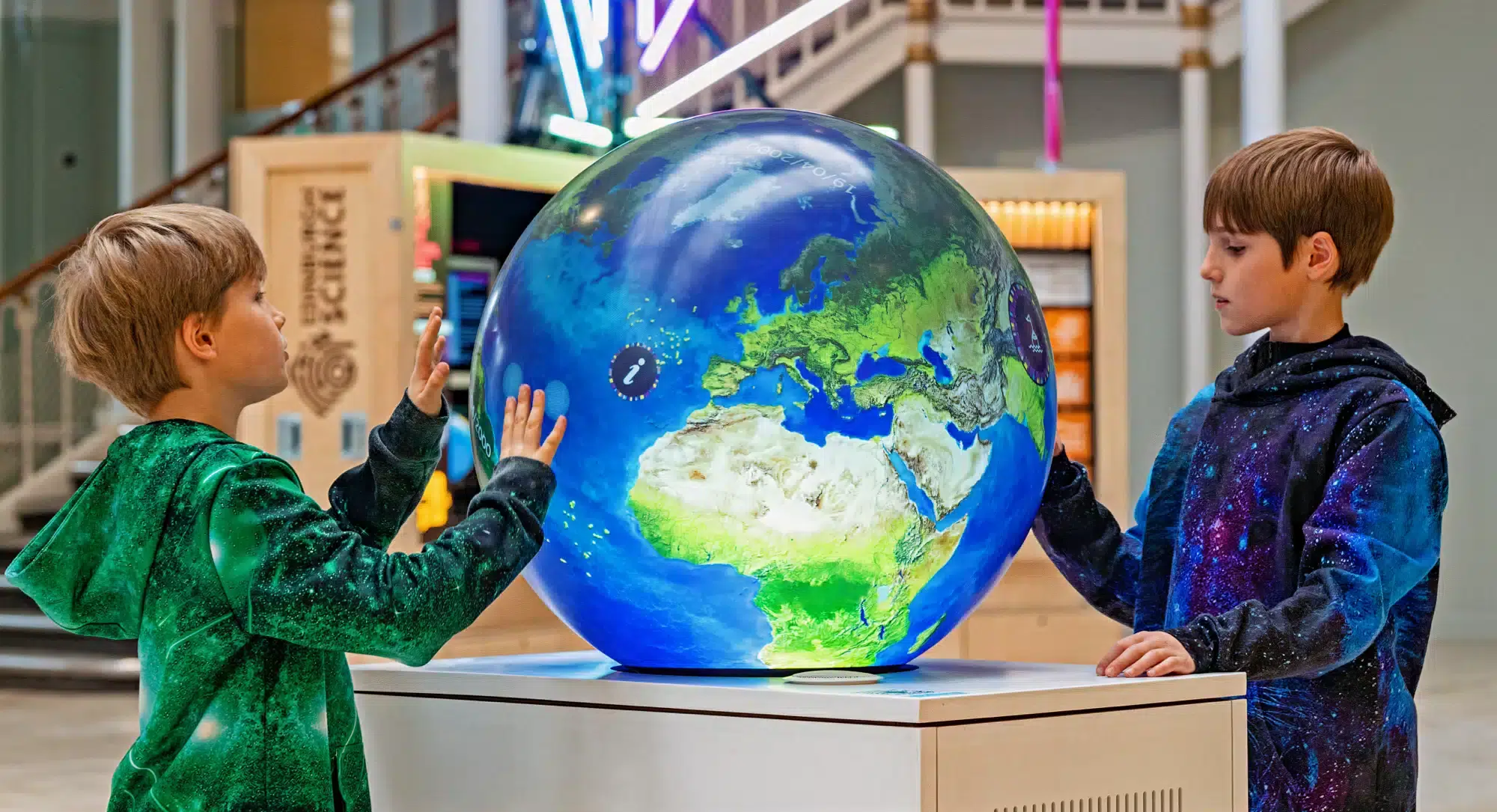 Two young boys are transfixed by the touch interactivity of the PufferTouch